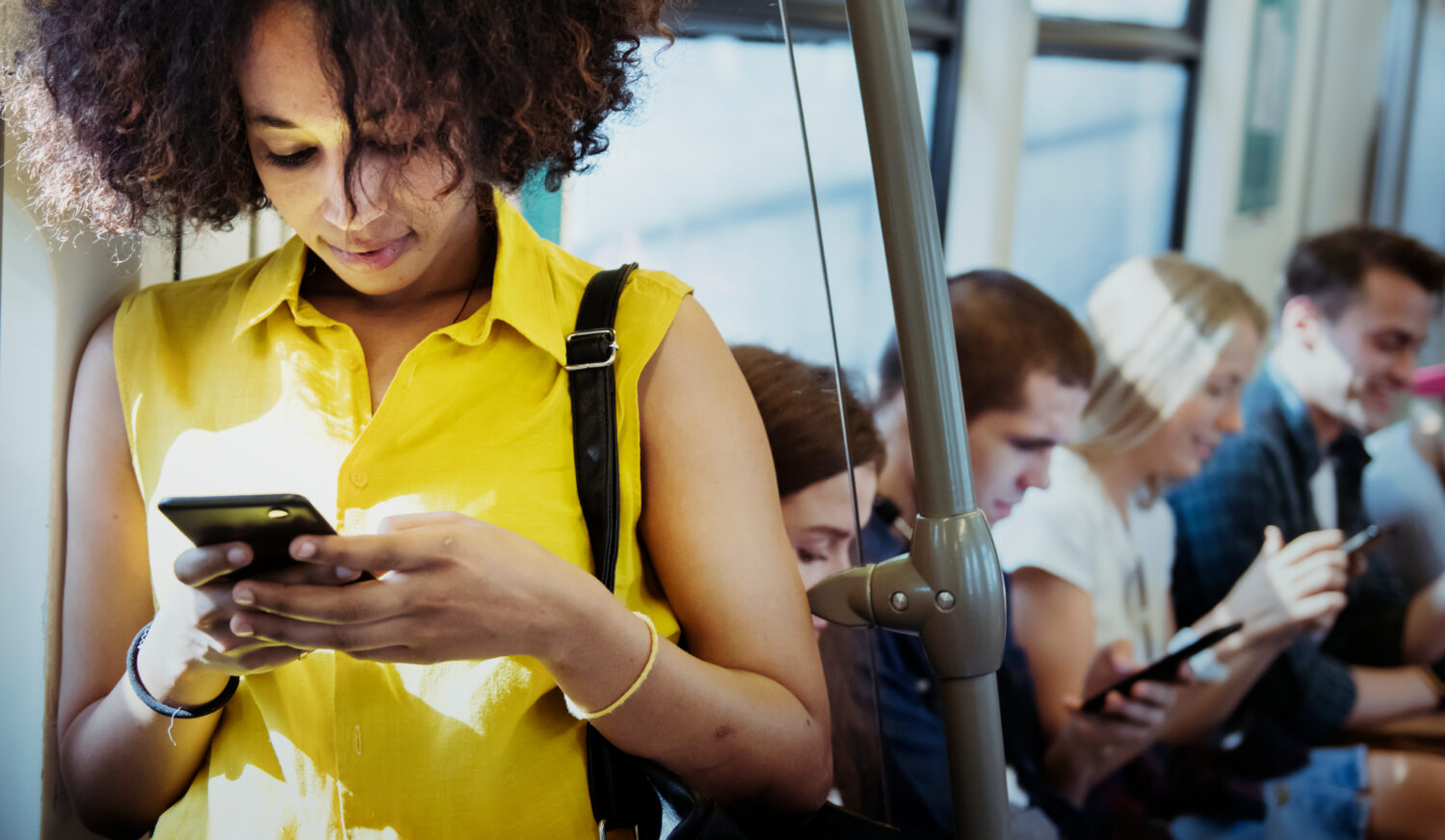 Junge Frau mit Smartphone in einer U-Bahn